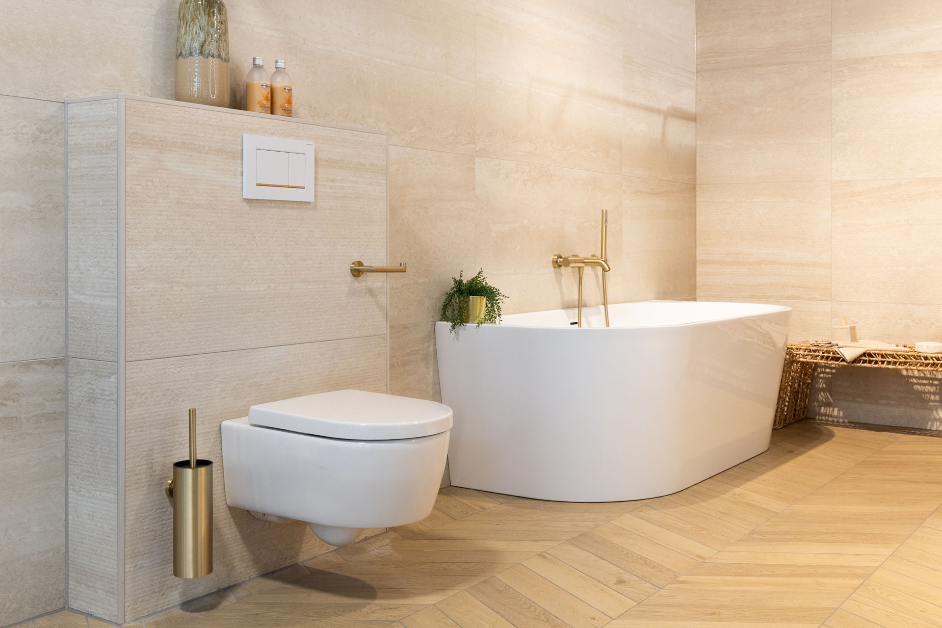 Luxe badkamer met vrijstaand ligbad, zwevend toilet en goudkleurige badkameraccessoires.