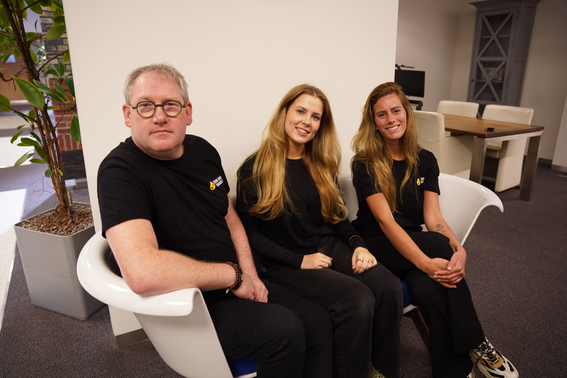 Team van Jouw Droombadkamer zit samen in een moderne showroomomgeving.