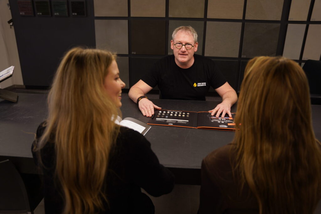 Badkameradviseur bespreekt materialen en ontwerp met klanten in showroom