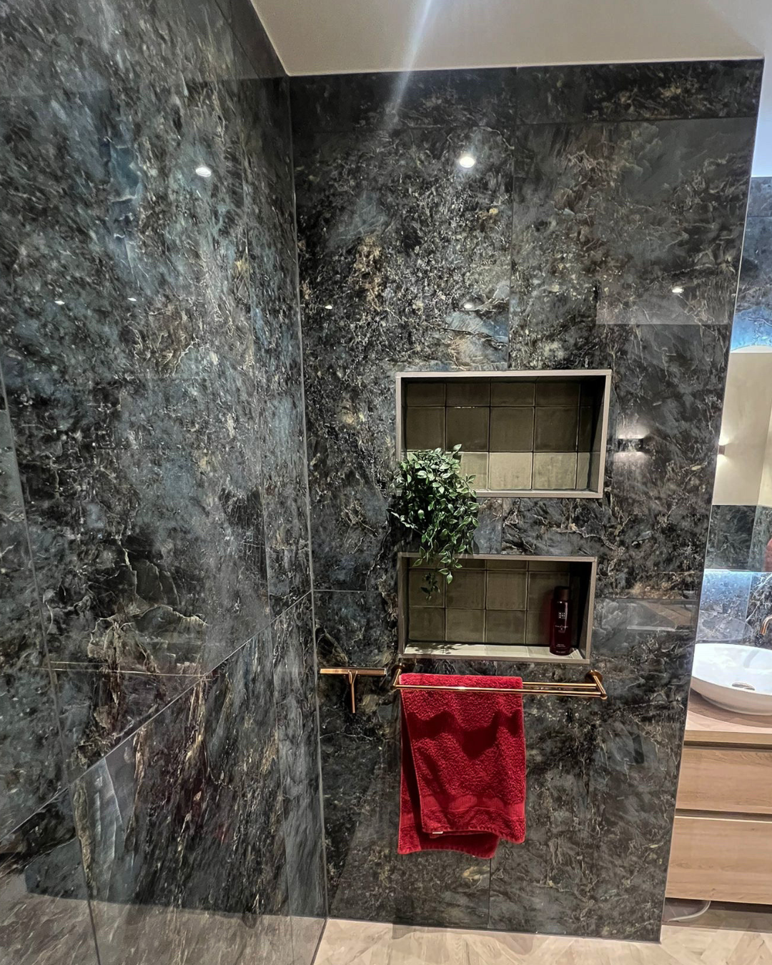 Luxe inloopdouche met donkere marmerlook tegels, ingebouwde nis en moderne afwerking