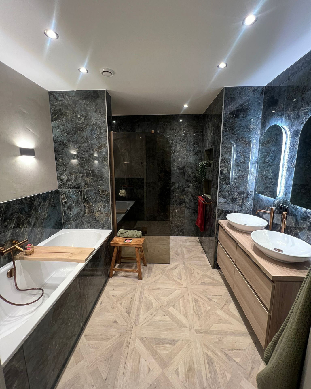 Stijlvolle badkamer met ligbad, dubbele wastafel en moderne hotel-chique uitstraling.
