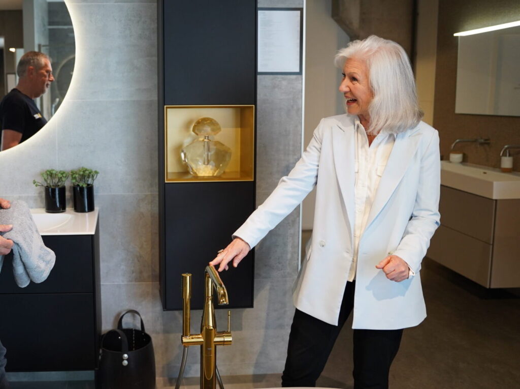 Senior klant krijgt badkameradvies in moderne badkamer showroom